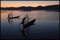 Leg-rowing Intha fishermen with lanterns at dusk. Inle Lake, Myanmar ( color)