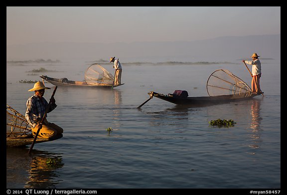 Intha fishermen rowing boats in early morning mist. Inle Lake, Myanmar