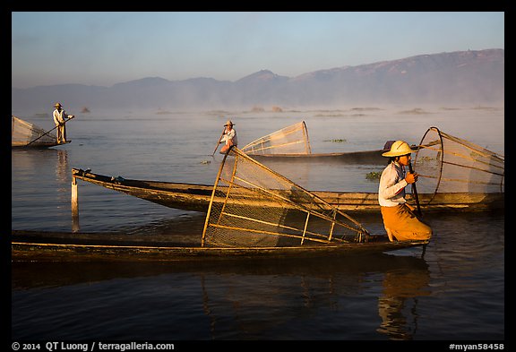 Intha fishermen with conical baskets in morning mist. Inle Lake, Myanmar