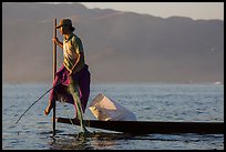 Fisherman pulling up net while leg-rowing. Inle Lake, Myanmar ( color)