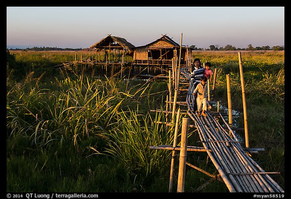 Family walking out of stilt house on precarious bridge. Inle Lake, Myanmar