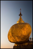 Pilgrim prays to the gleaming Golden Rock at sunset. Kyaiktiyo, Myanmar ( color)