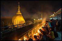 Pilgrims pray with candles behind the Golden Rock. Kyaiktiyo, Myanmar ( color)