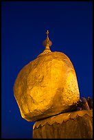 Pilgrims affix golden leaves to balancing boulder stupa at dawn. Kyaiktiyo, Myanmar ( color)