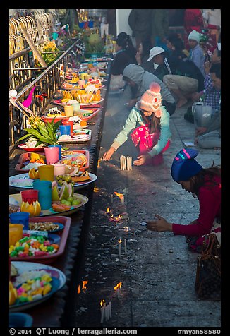 Morning food offering and pilgrims with cold weather hats. Kyaiktiyo, Myanmar (color)