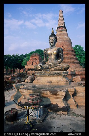 Classic sitting Buddha image and tiered, bell-shaped chedi. Sukothai, Thailand