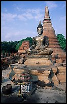 Classic sitting Buddha image and tiered, bell-shaped chedi. Sukothai, Thailand (color)