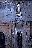 Monumental Buddha image seen between walls,  Wat Si Chum. Sukothai, Thailand ( color)