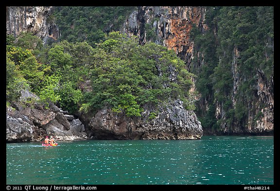Couple paddling below steep cliffs. Krabi Province, Thailand