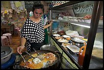 Woman adding spices to Pad Thai, Ko Phi-Phi island. Krabi Province, Thailand ( color)
