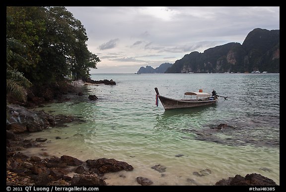 Boat, clear water, stormy skies, Phi-Phi island. Krabi Province, Thailand