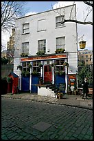 Cobblestone mews, pub, and man standing outside. London, England, United Kingdom ( color)