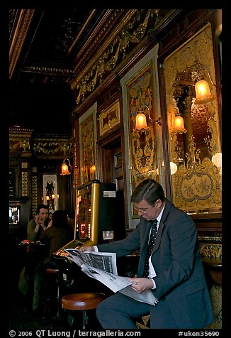 Man reading newspaper in front of etched mirrors, pub Princess Louise. London, England, United Kingdom (color)