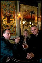 Friends cheering up with a beer in front of echted glass and fine tiles of pub Princess Louise. London, England, United Kingdom (color)