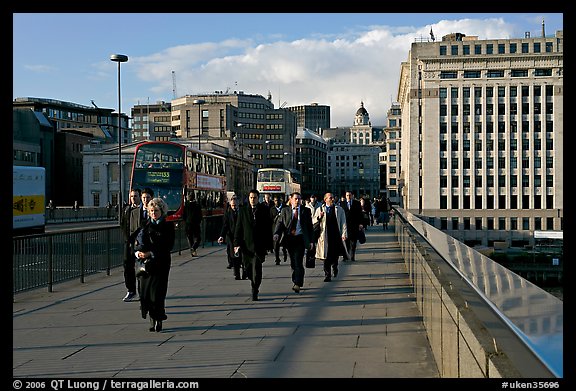 Office workers pouring out of the city of London across London Bridge, late afternoon. London, England, United Kingdom (color)