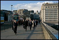 Office workers pouring out of the city of London across London Bridge, late afternoon. London, England, United Kingdom