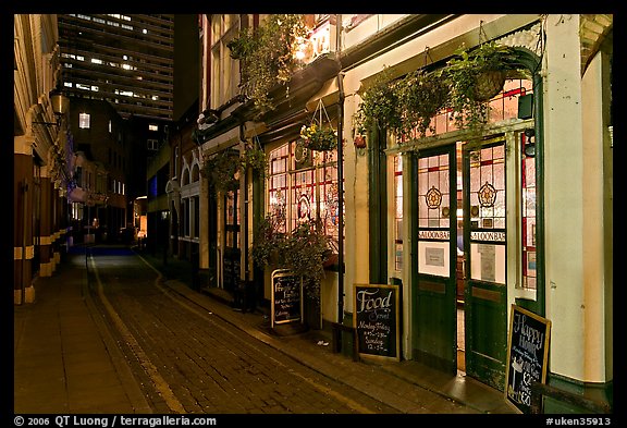 Saloon bar and cobblestone alley at night. London, England, United Kingdom (color)