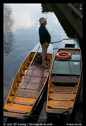 Man standing in a rowboat, old town moat. Canterbury,  Kent, England, United Kingdom (color)