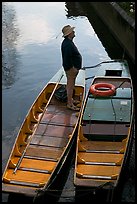 Man standing in a rowboat, old town moat. Canterbury,  Kent, England, United Kingdom ( color)
