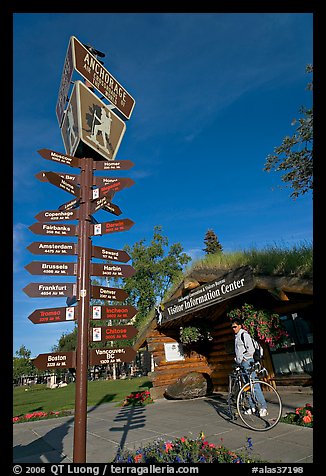 Sign Air Crossroads of the World, man on bicycle in front of visitor center. Anchorage, Alaska, USA (color)