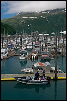 Small boat loaded at pier, harbor, and mountains. Whittier, Alaska, USA (color)