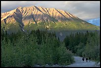 People strolling on unpaved road at sunset. McCarthy, Alaska, USA (color)