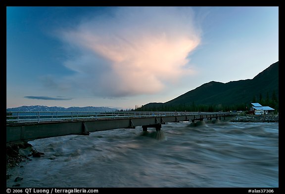 Kennicott River swelled from the Hidden Lake flood rushing against footbridge, sunset. McCarthy, Alaska, USA