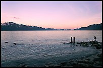 Boy standing in front of Resurrection Bay, sunset. Seward, Alaska, USA