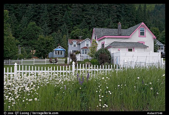 White picket fence and houses with pastel trims. Seward, Alaska, USA