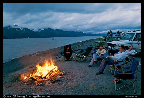 Sitting by campfire at midnight, waterfront campground. Seward, Alaska, USA (color)
