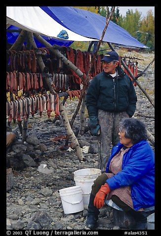 Inupiaq Eskimo man and woman next to fish hung for drying, Ambler. North Western Alaska, USA