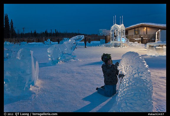 Child amongst ice sculptures at dusk. Fairbanks, Alaska, USA