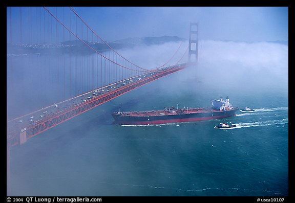 Tanker ship cruising under the Golden Gate Bridge in the fog. San Francisco, California, USA