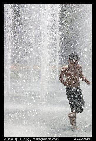 Boy refreshing himself  Cesar de Chavez Park. San Jose, California, USA (color)