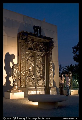 A couple contemplates Rodin's Gates of Hell at night. Stanford University, California, USA