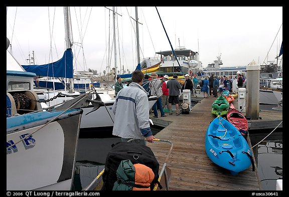 Pier with passengers preparing to board a tour boat with outdoor gear, Ventura. California, USA