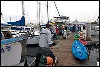 Pier with passengers preparing to board a tour boat with outdoor gear, Ventura. California, USA ( color)