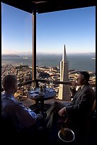 Businessmen with a bottle of Champagne in the Carnelian Room with panoramic view of the City. San Francisco, California, USA (color)