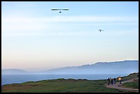 Hang gliders soaring above hikers, Fort Funston, late afternoon. San Francisco, California, USA ( color)