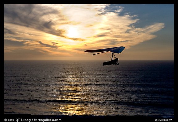 Soaring in a hang glider above the ocean at sunset,  Fort Funston. San Francisco, California, USA (color)
