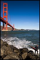 Surfer poised to jump in water below the Golden Gate Bridge. San Francisco, California, USA (color)