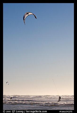 Kite surfing in Pacific Ocean waves, late afternoon. San Francisco, California, USA (color)