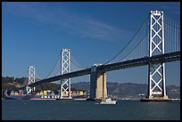 Cargo ship passing below the Bay Bridge. San Francisco, California, USA (color)