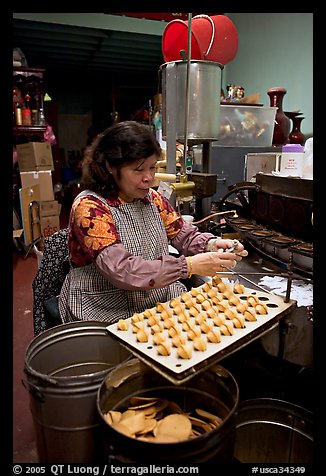 Woman folding fortune cookies, Chinatown. San Francisco, California, USA (color)