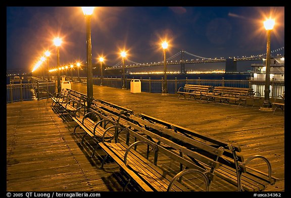 Benches and lights on Pier 7 with Bay Bridge in background, evening. San Francisco, California, USA