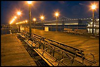 Benches and lights on Pier 7 with Bay Bridge in background, evening. San Francisco, California, USA (color)