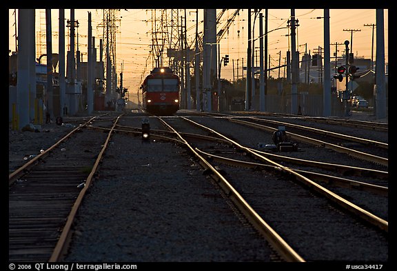Railroad tracks, train, and power lines, sunrise. San Diego, California, USA