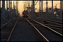Railroad tracks, train, and power lines, sunrise. San Diego, California, USA (color)