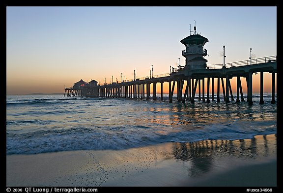 Huntington Pier reflected in wet sand at sunset. Huntington Beach, Orange County, California, USA