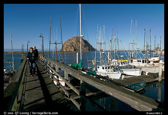 People walking on a deck in the harbor. Morro Bay, USA